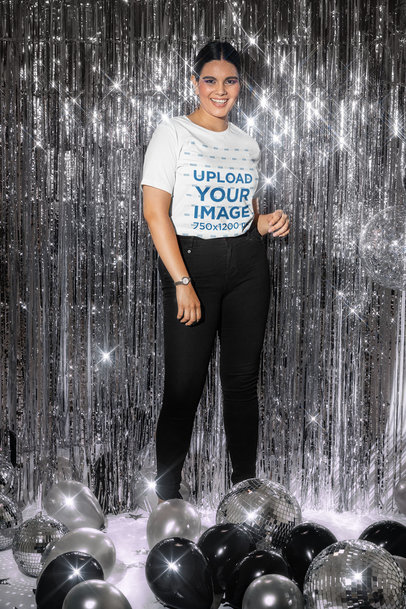 New Year's-Themed Mockup of a Woman in a Bella Canvas T-Shirt Posing by a Sparkling Curtain
