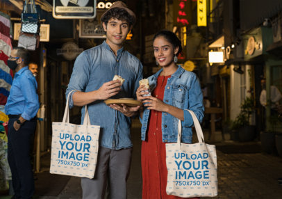 Tote Bag Mockup of a Couple of Tourists Trying Street Food